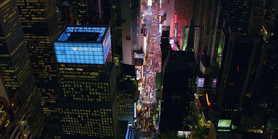 Tall city buildings illuminate the night sky