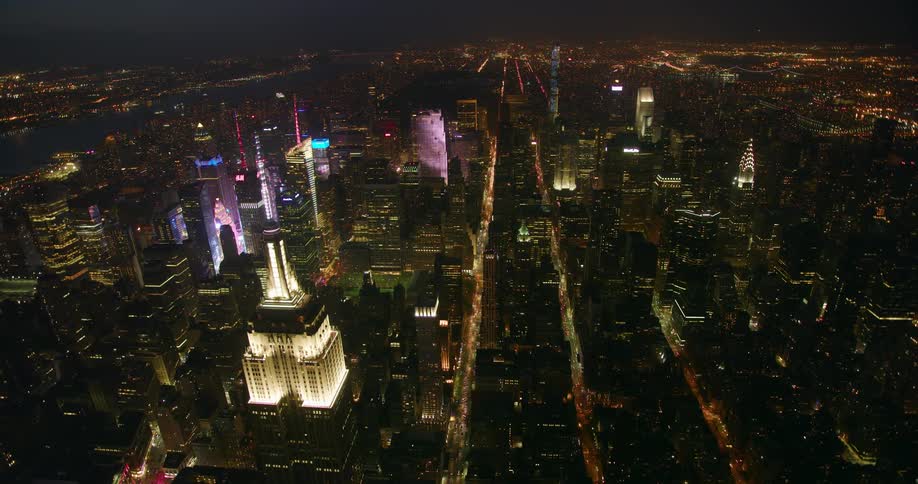 Tall city buildings illuminate the night sky