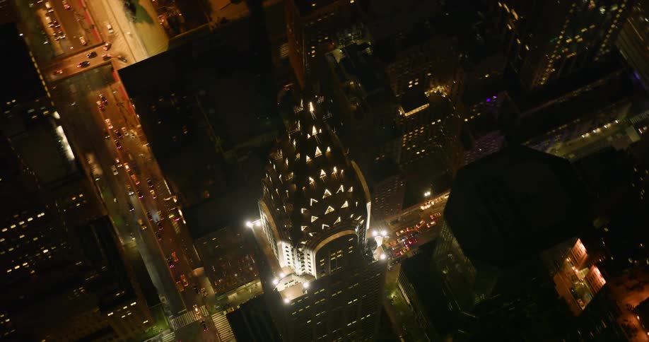 A tall tower in the city illuminates the night sky