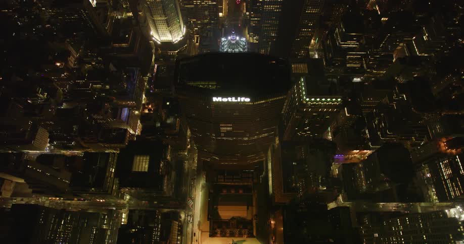 Tall city buildings illuminate the night sky