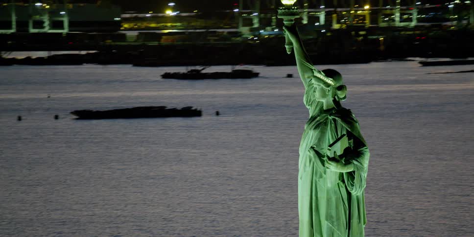 The statue of liberty stands tall in the water