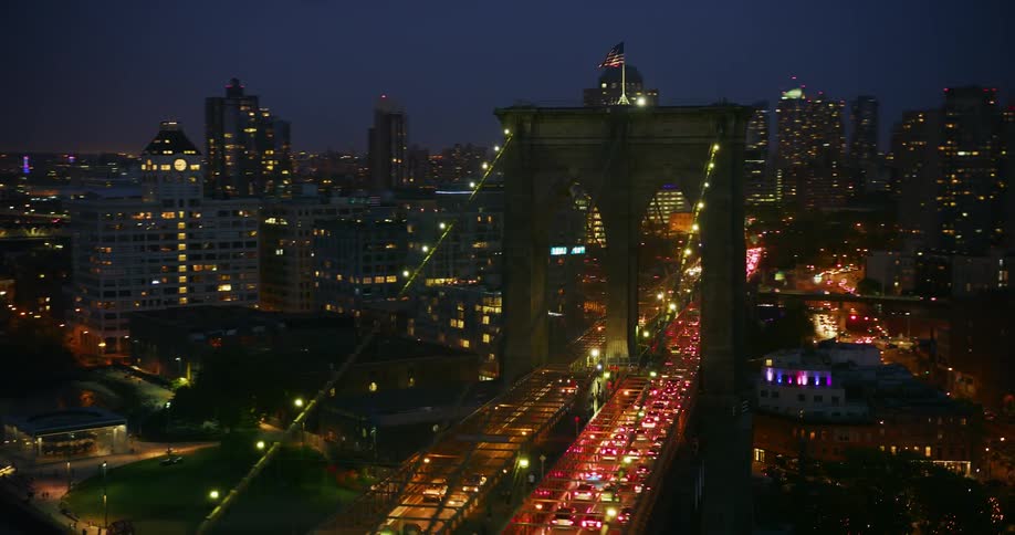 The brooklyn bridge is congested with traffic as its flown over