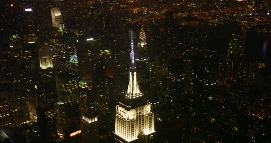 Tall city buildings illuminate the night sky