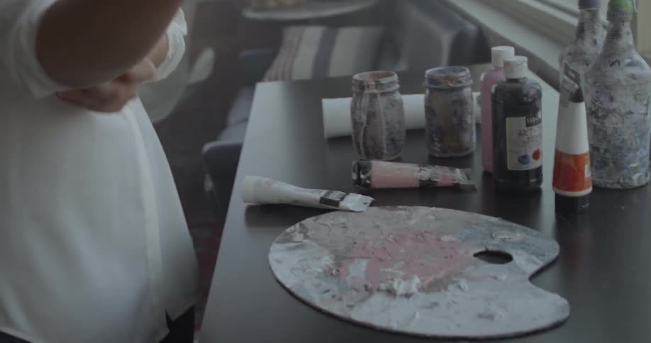 Woman selects paint and walks to her workbench