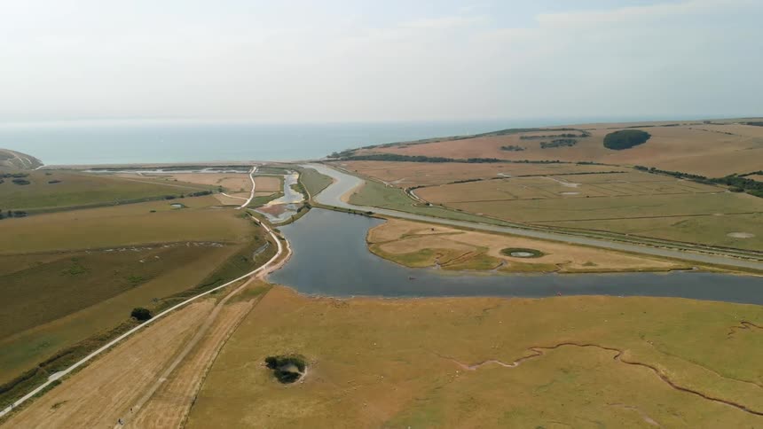 Grassy flatlands extend inland from an ocean