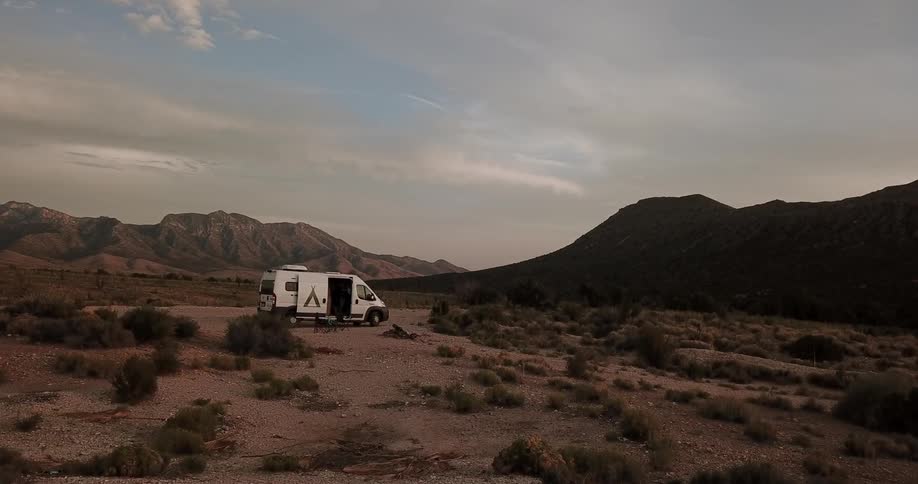 A van sits parked in the desert