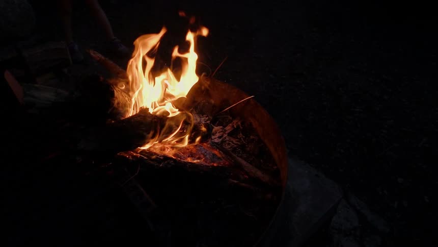 A campfire burns at night