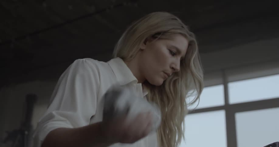 A woman shakes a can of spray paint