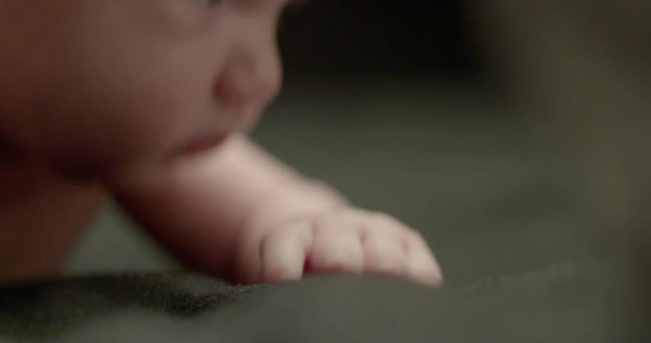 Baby wiggles its fingers and looks around