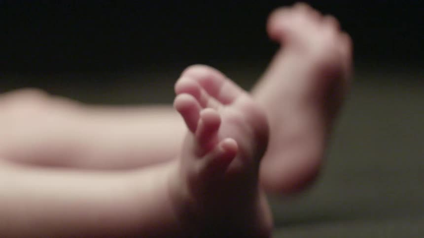 Infant stretching its legs and feet