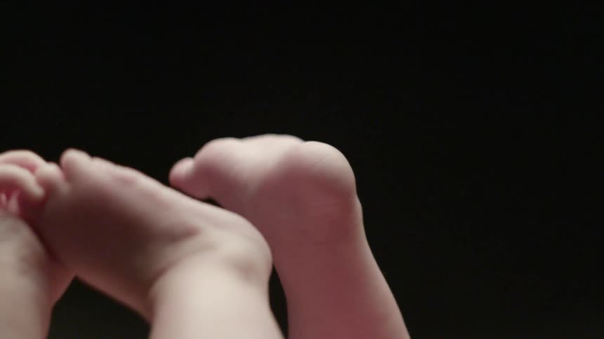 A baby grabs its feet