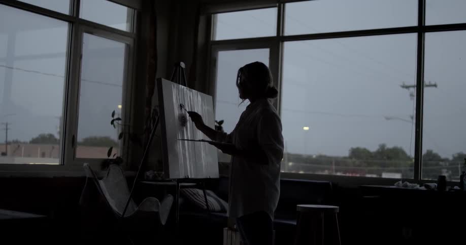 An artist paints on a canvas