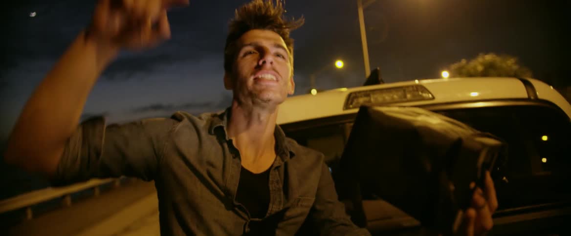 A man riding in the back of a pickup is commenting as he watches a monitor