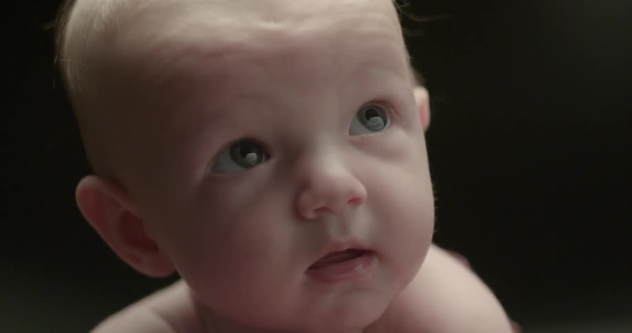 Infant looking at something and then smiling