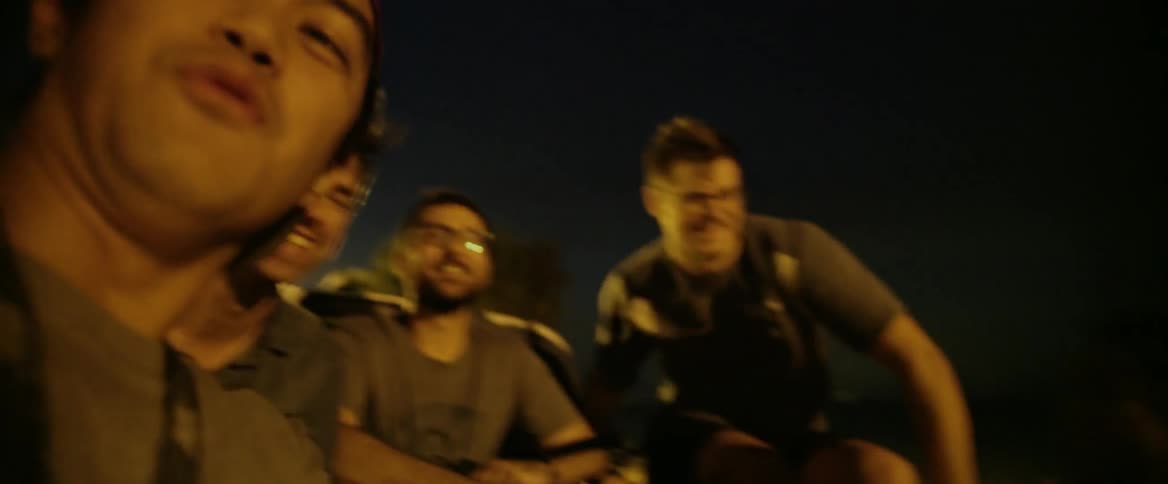 A group of people laugh and smile while riding in the bed of a truck