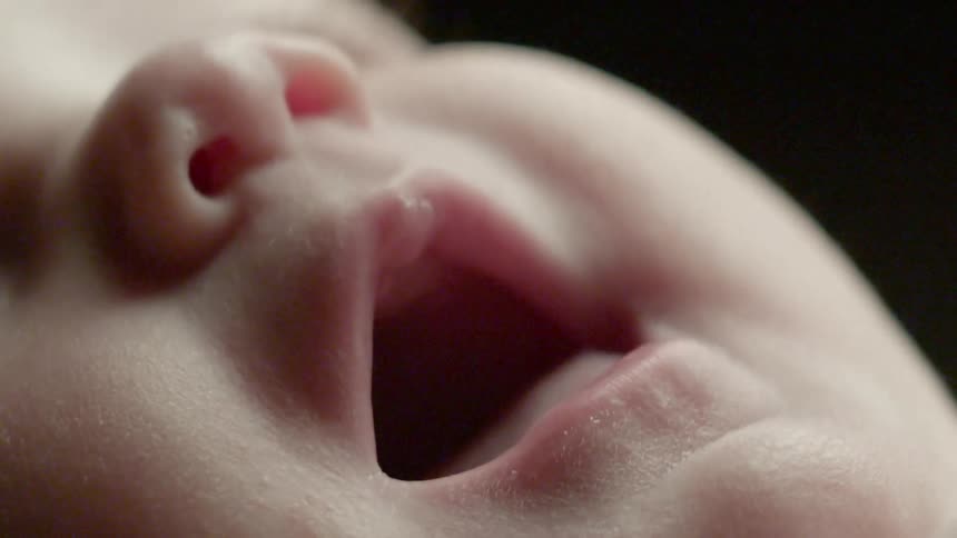 A baby is opening its mouth and moving its tongue