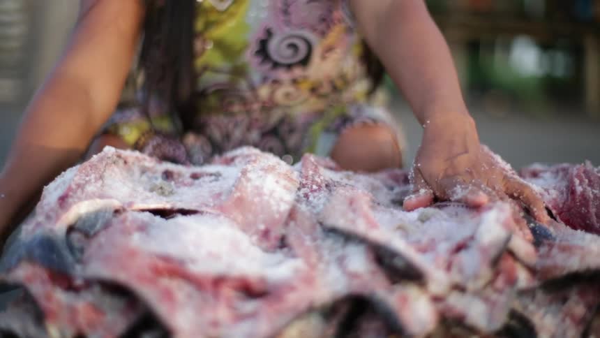 A person salting fish