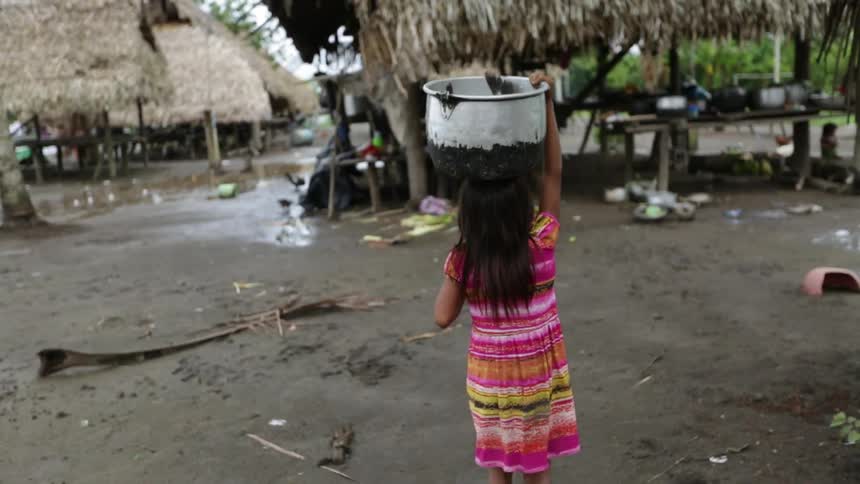 Girl walking carrying a bucket on her head