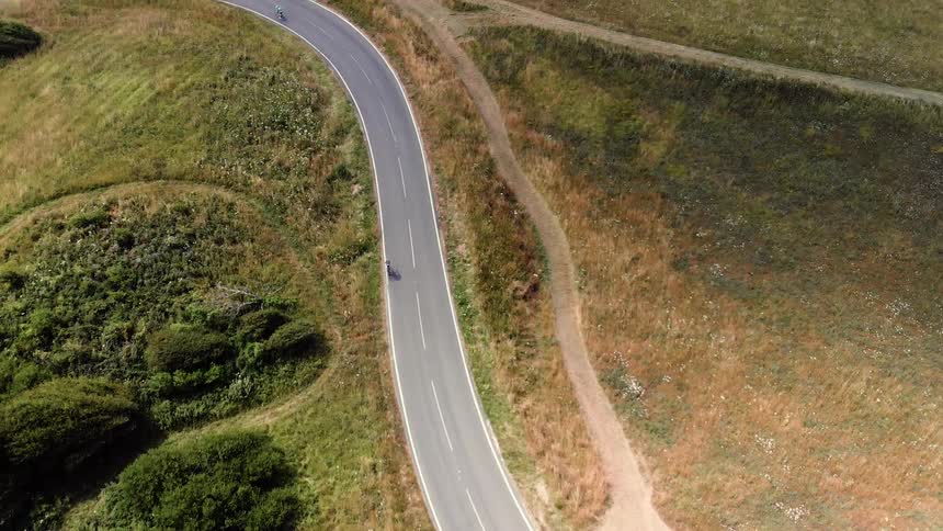 Bike riders travel on a rural mountain road