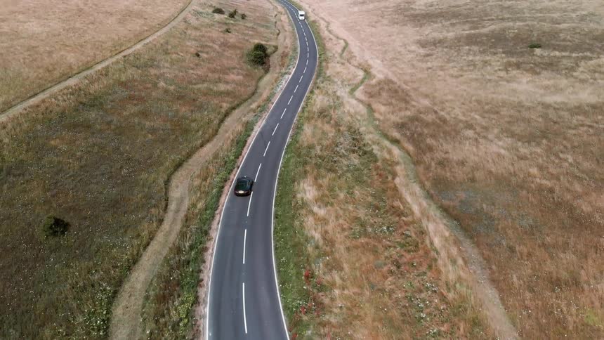 A car going down a windy road passing another car
