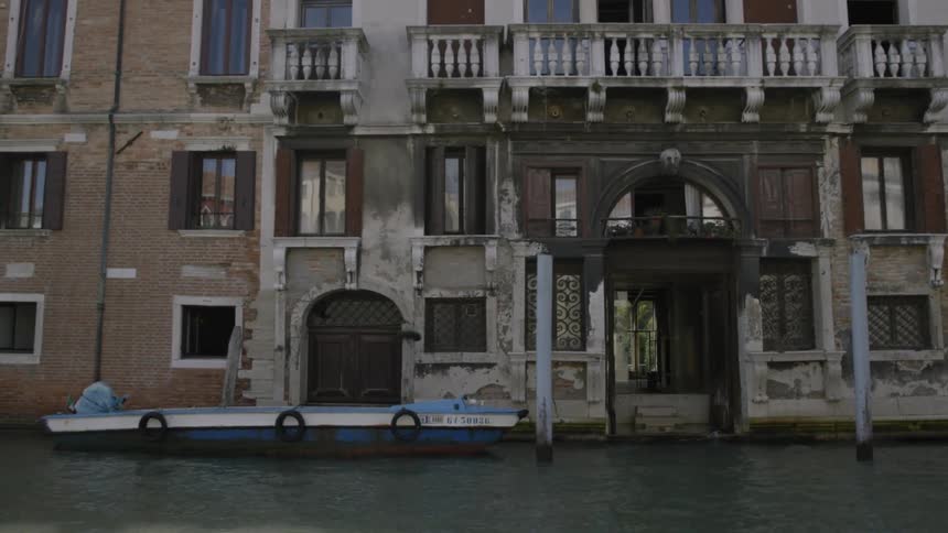 Boats are docked in front of old buildings sitting on the water in a canal