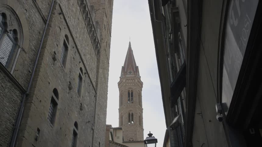 A bell tower juts up between two buildings
