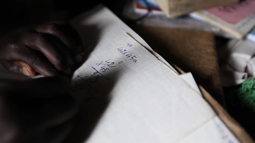 A person doing a multiplication math problem on paper