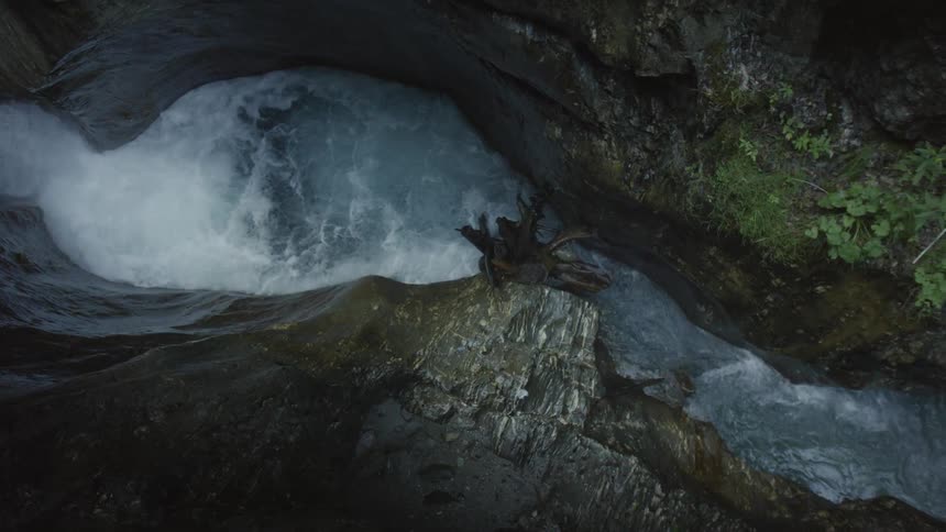 Rocked walled waterfall leading to a basin of water