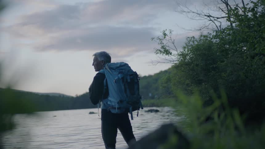 A hiker stands in a lake