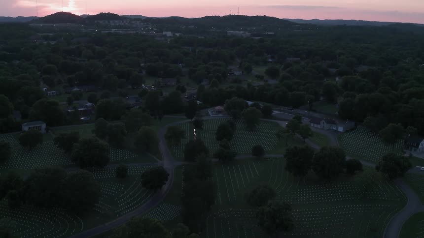 Trees sparsely cover a park behind houses