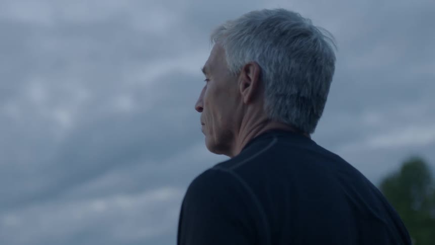A man is looking out over a lake