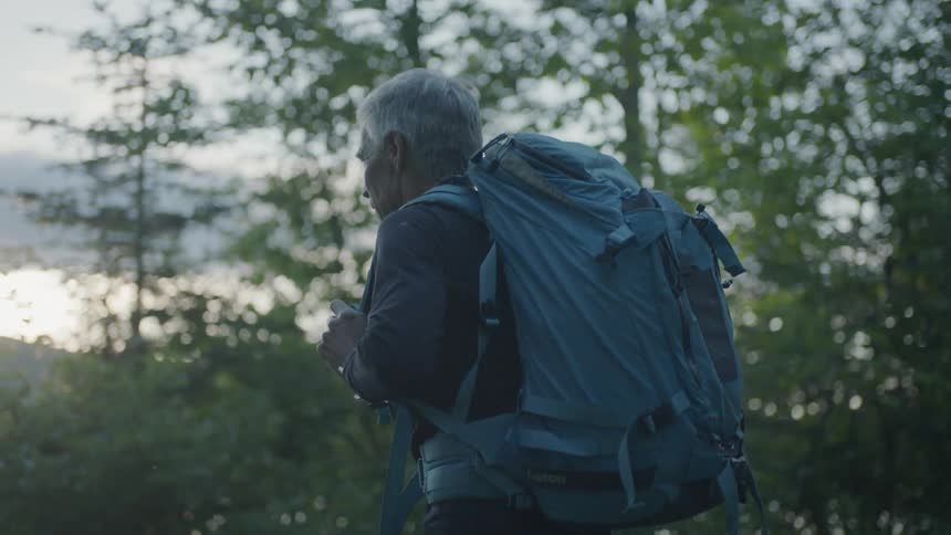 A man hikes near trees