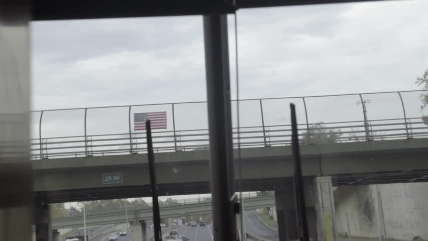 Cars drive down the highway past a flag above