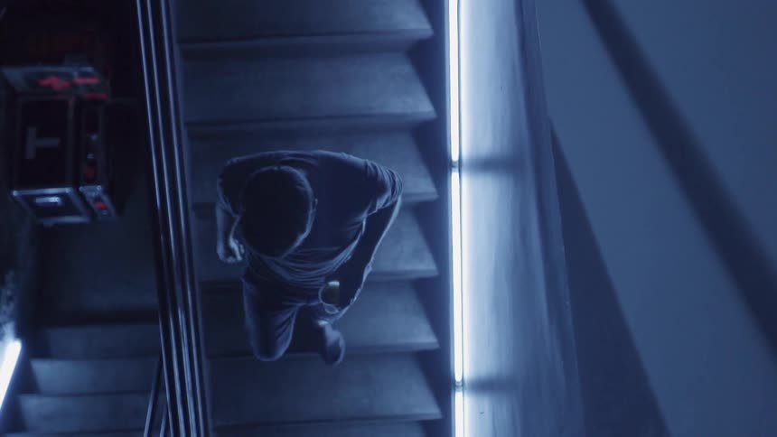 Man with drink descends staircase