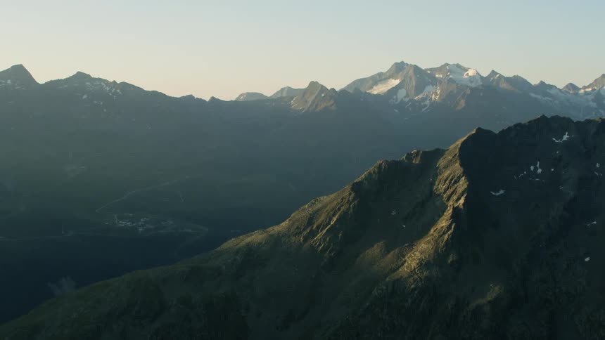 The long mountain range is covered with light fog