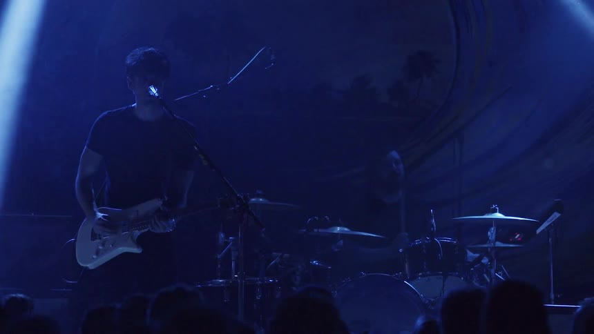 A band is performing on stage in front of a crowd