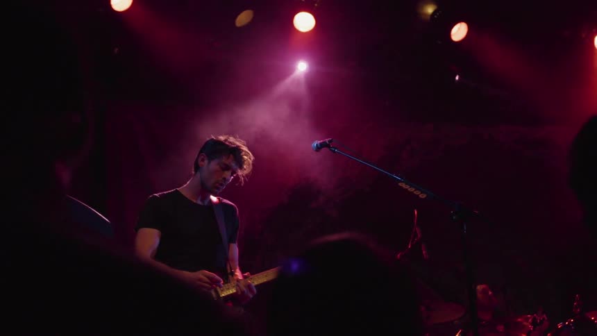 Man plays guitar in front of a crowd of people