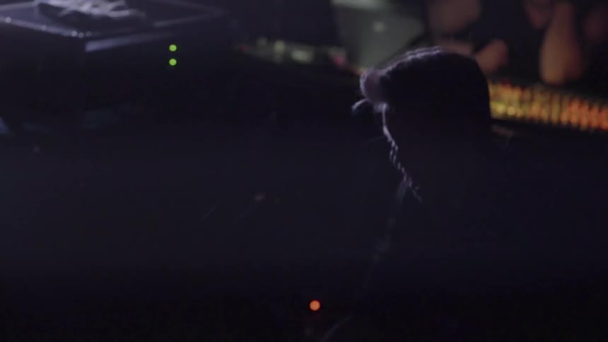 A man is playing drums with lights flashing on him