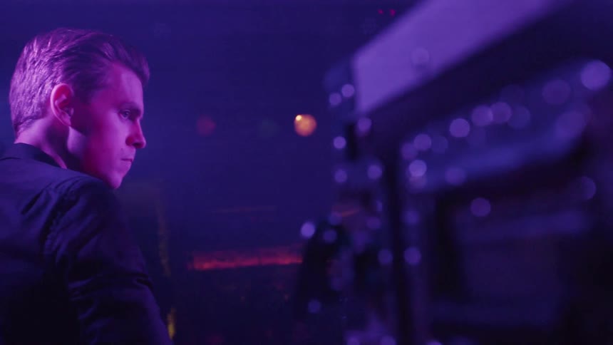 A man is performing on the dark stage