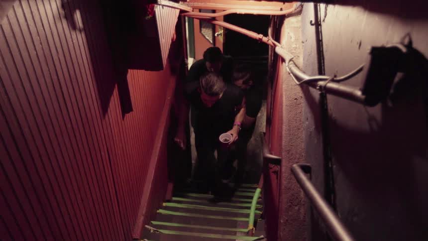 Men walk up a narrow staircase