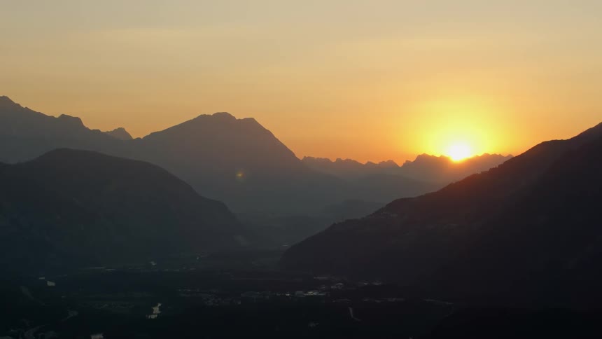 The sun sets over a mountain range