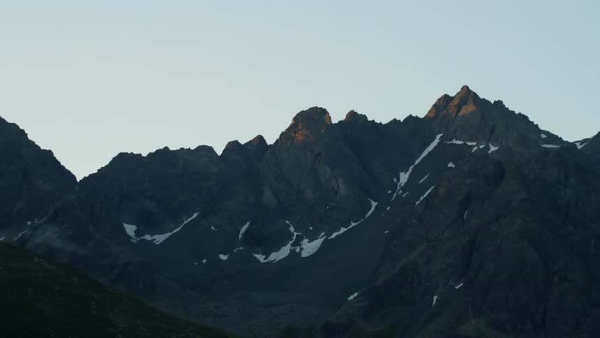 Snow and ice sparsely cover the stone mountains