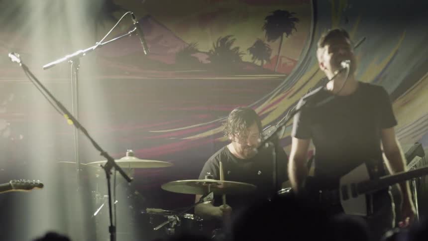 Band playing on stage while lights flash