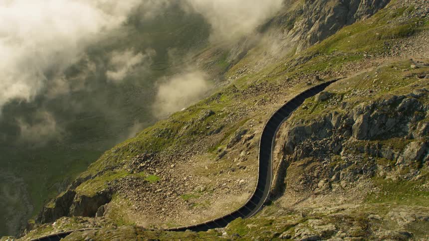 Clouds hover next to a mountainside