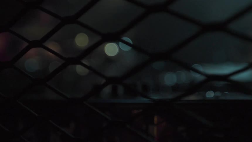 The lights can be seen through the fence holes