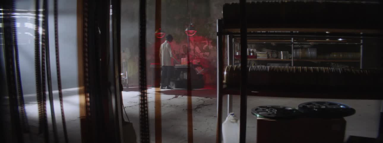 A woman develops film in a dark room