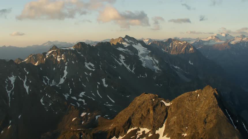 Helicopter Timelapse - Snow and ice sparsely cover the stone mountains
