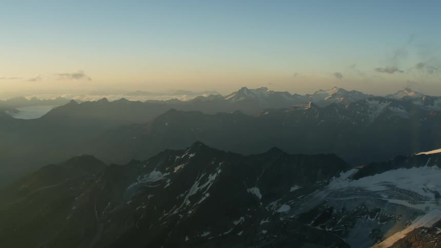 The sun is setting behind this large mountain range