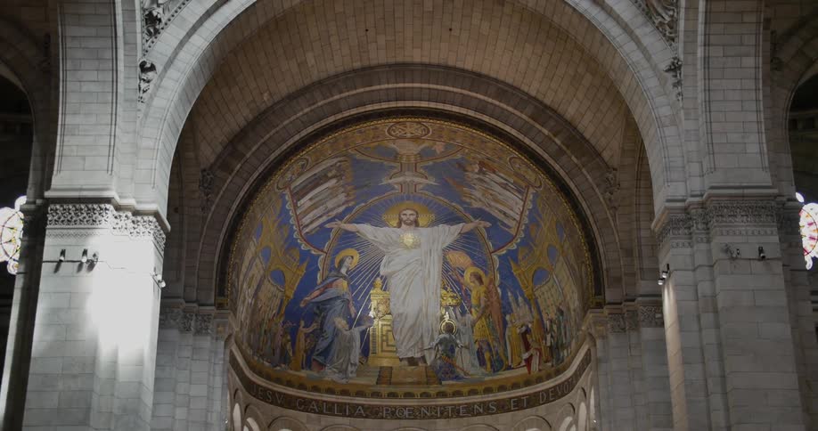 The vaulted ceiling of a cathedral with a mural of jesus