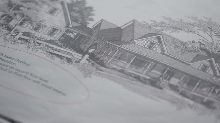 A drawing of a house sits on a table